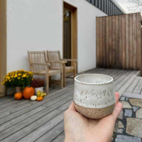 Kropenatý šálek v ruce před apartmány Aparthouse Lubno